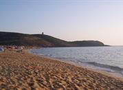 La spiaggia di sabba d'oro, il mare turchese e la torre in fondo