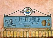 Montone, insegna artistica di un negozio artigianale nelle vie del borgo
